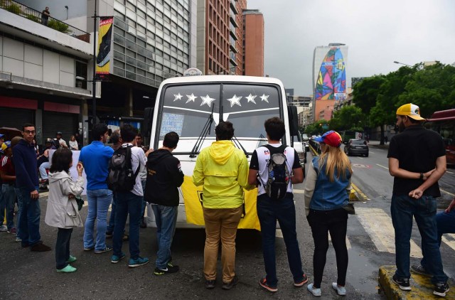 Demonstrators block a street during a protest against Venezuelan President Nicolas Maduro in Caracas, on May 2, 2017. Venezuelan President Nicolas Maduro called for a new constitution Monday as he fights to quell a crisis that has led to more than a month of protests against him and deadly street violence. The opposition slammed the tactic as a "coup d'etat" and urged protesters to "block the streets" from Tuesday. It said it was organizing a "mega protest" for Wednesday. / AFP PHOTO / RONALDO SCHEMIDT