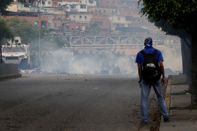 A demonstrator stands in front of Venezuelan national guards during a protest against Venezuela's President Nicolas Maduro's government in Caracas, Venezuela May 2, 2017. REUTERS/Carlos Garcia Rawlins