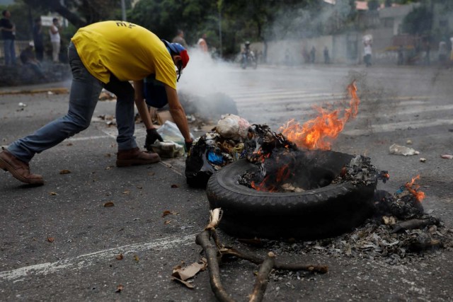 A demonstrator builds a barricade during a protest against Venezuela's President Nicolas Maduro's government in Caracas, Venezuela May 2, 2017. REUTERS/Carlos Garcia Rawlins