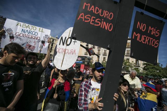 Casi un millar de opositores al gobierno venezolano se han concentrado hoy en la madrileña Plaza de Isabel II para solicitar a la comunidad internacional una mayor condena al presidente de su país Nicolás Maduro. EFE/Santi Donaire