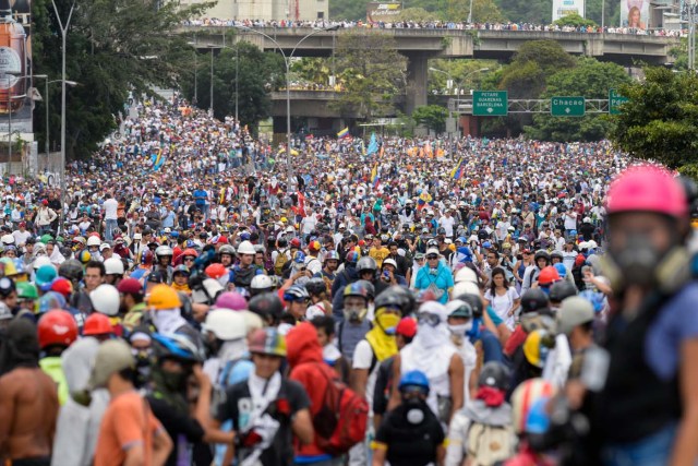 Opposition activists march during a protest against the government of President Nicolas Maduro in Caracas on May 31, 2017.  Venezuelan authorities on Wednesday began signing up candidates for a planned constitutional reform body, a move that has inflamed deadly unrest stemming from anti-government protests. Opponents of socialist President Nicolas Maduro say he aims to keep himself in power by stacking the planned "constituent assembly" with his allies.  / AFP PHOTO / FEDERICO PARRA