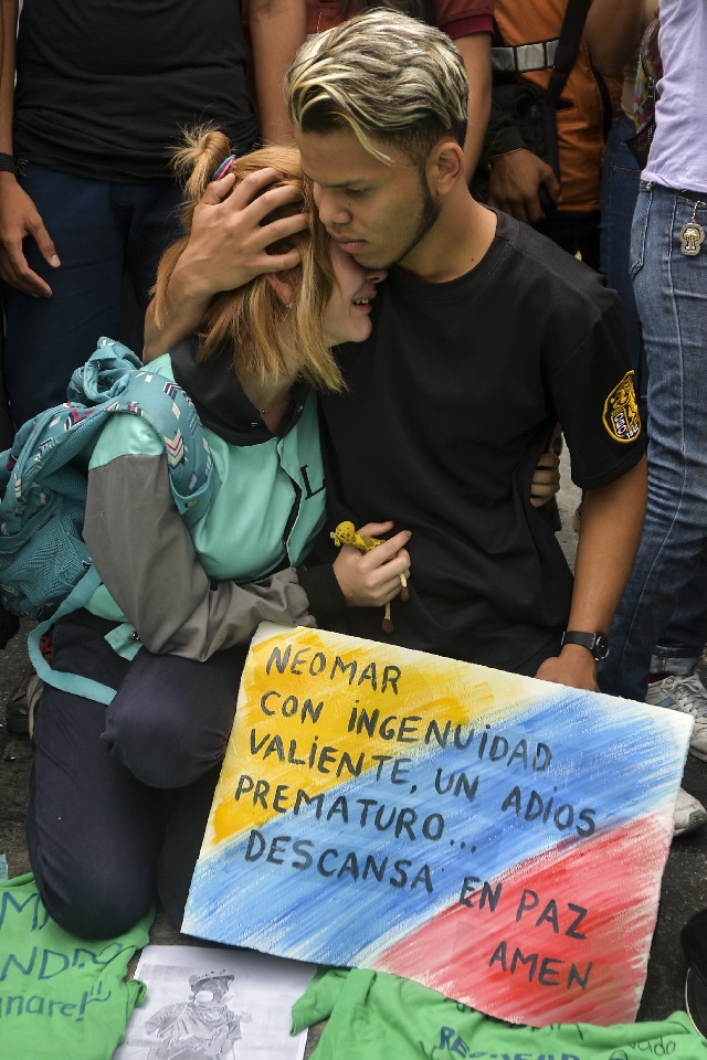 Friends of opposition activist Neomar Lander, 17, who died on the eve during a protest against the government of President Nicolas Maduro in Caracas, Venezuela, take part in a ceremony in his honor, on June 8, 2017. / AFP PHOTO / LUIS ROBAYO