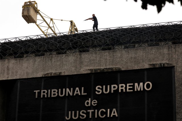 A man aims his weapon toward demonstrators (not pictured) as they attack a Supreme Justice Court branch office during riots at a rally against Venezuelan president Nicolas Maduro's government in Caracas, Venezuela, June 7, 2017. REUTERS/Carlos Garcia Rawlins