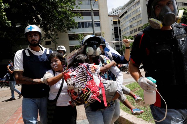 A woman and a child affected by tear gas are assisted by volunteer members of a primary care response team during a rally against Venezuela's President Nicolas Maduro's government in Caracas, Venezuela June 14, 2017.  REUTERS/Carlos Garcia Rawlins