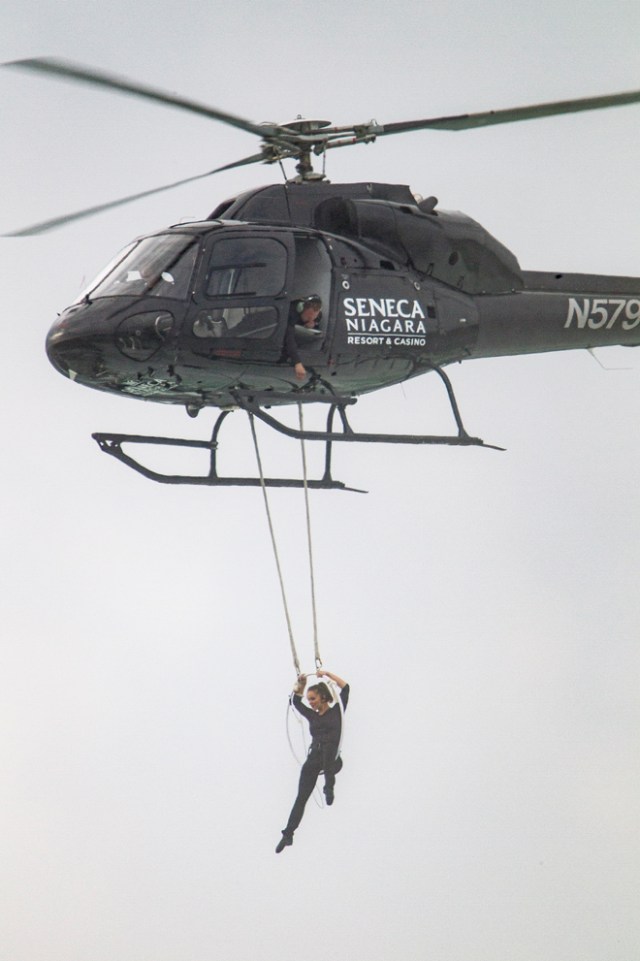 Aerialist Erendira Wallenda hangs beneath a helicopter during a stunt over the Horseshoe Falls at Niagara Falls, New York, June 15, 2017. / AFP PHOTO / Geoff Robins