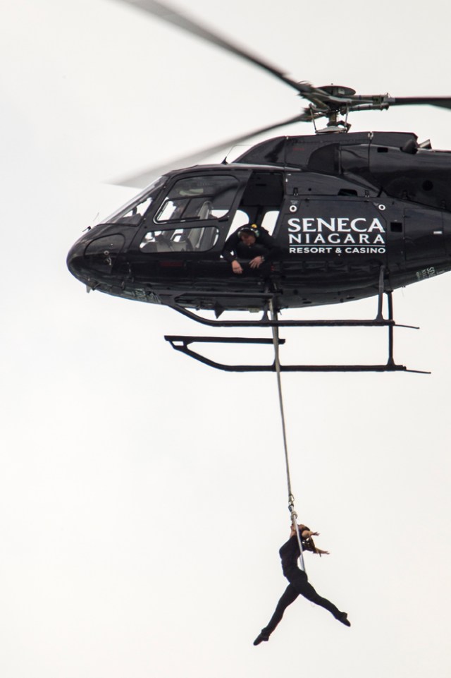 Aerialist Erendira Wallenda hangs beneath a helicopter during a stunt over the Horseshoe Falls at Niagara Falls, New York, June 15, 2017. / AFP PHOTO / Geoff Robins