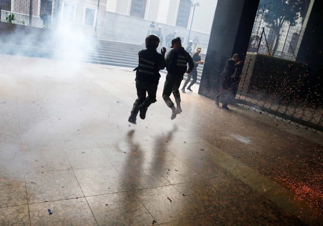 Members of the National Guard react as government supporters (not pictured) throw firecrackers at the National Assembly in Caracas, Venezuela, July 5, 2017.   REUTERS/Carlos Garcia Rawlins