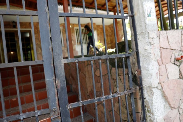 A woman walks next to a gate that was broken during a raid of Venezuelan security forces, according to residents, in an apartment complex of Los Teques, Venezuela, July 14, 2017. Picture taken July 14, 2017. REUTERS/Andres Martinez Casares