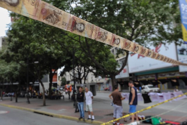 CAR107. CARACAS (VENEZUELA), 10/07/2017.- Manifestantes bloquean una vía con cintas hechas de monedas y billetes hoy, lunes 10 de julio de 2017, en Caracas (Venezuela). Los opositores venezolanos atendieron hoy a la convocatoria de realizar un "trancazo" de calles en todo el país contra la "dictadura" que se espera se extienda por diez horas, después de que la alianza antichavista intentara reducir esta protesta a solo dos horas. EFE/Miguel Gutiérrez