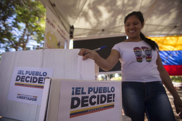 BRA100. BRASILIA (BRASIL), 16/07/2017.- La comunidad venezolana de Brasilia vota en la calle la consulta popular impulsada por los opositores del presidente Nicolás Maduro ante la negativa del Ayuntamiento a que se realizase en un centro cívico por la falta de permisos hoy, domingo 16 de julio de 2017, en Brasilia (Brasil). La oposición venezolana lanza este domingo su mayor desafío al Gobierno del presidente Nicolás Maduro con la convocatoria de una consulta calificada de ilegal desde el oficialismo en la que espera que el pueblo se pronuncie masivamente contra el proceso constituyente impulsado por el chavismo. EFE/Joédson Alves