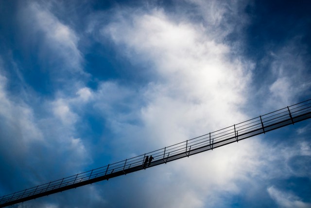 A couple walks on the "Europabruecke",  supposed to be the world's longest pedestrian suspension bridge with a length of 494m, prior to the official inauguration of the construction in Randa, Switzerland, on Saturday, July 29, 2017. The bridge is situated on the Europaweg that connects the villages of Zermatt and Graechen. (Valentin Flauraud/Keystone via AP)