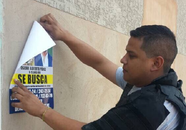 Efectivos del Cicpc  fijando carteles con la cara del piloto Óscar Pérez // Foto @CICPC_ZULIA 