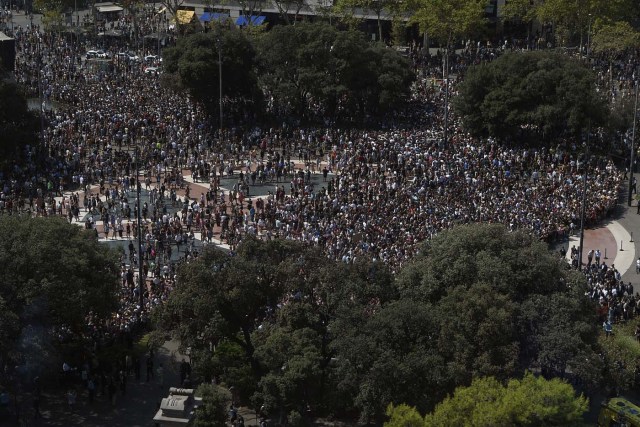 People leave the Plaza de Catalunya after observing a minute of silence for the victims of the Barcelona attack on August 18, 2017, a day after a van ploughed into the crowd, killing 13 persons and injuring over 100 on the Rambla in Barcelona. Drivers have ploughed on August 17, 2017 into pedestrians in two quick-succession, separate attacks in Barcelona and another popular Spanish seaside city, leaving 13 people dead and injuring more than 100 others. In the first incident, which was claimed by the Islamic State group, a white van sped into a street packed full of tourists in central Barcelona on Thursday afternoon, knocking people out of the way and killing 13 in a scene of chaos and horror. Some eight hours later in Cambrils, a city 120 kilometres south of Barcelona, an Audi A3 car rammed into pedestrians, injuring six civilians -- one of them critical -- and a police officer, authorities said. / AFP PHOTO / LLUIS GENE