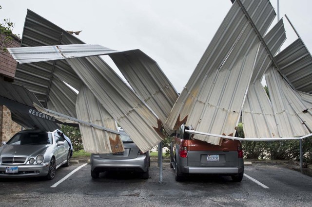 Cars are seen below a collapsed shelter following the passage of Hurricane Harvey on August 26, 2017 in Galveston, Texas. / AFP PHOTO / Brendan Smialowski