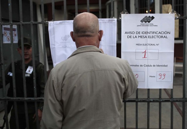 An man checks electoral lists before voting during the Constituent Assembly election in Caracas, Venezuela, July 30, 2017. REUTERS/Marco Bello