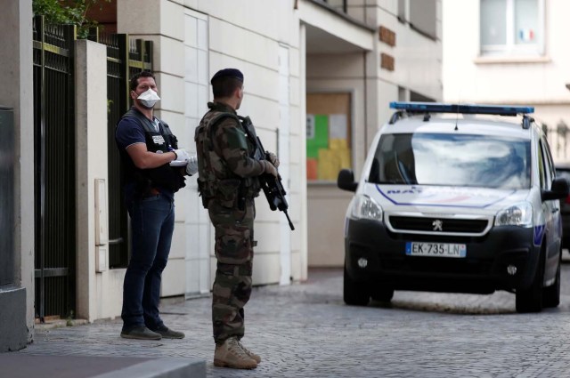 A police investigator and an armed soldier work near the scene where French soliders were hit and injured by a vehicle in the western Paris suburb of Levallois-Perret, France, August 9, 2017.     REUTERS/Benoit Tessier