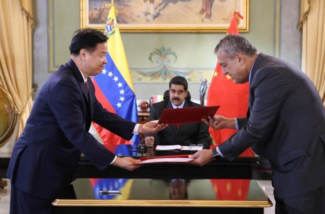 En la imagen de archivo se ve al presidente de Venezuela, Nicolás Maduro, mientras el presidente de aquel entonces de Petrochina, Wang Ying, y el ministro de petroleo de Venezuela de ese momento, y presidente de PDVSA, Eulogio del Pino, firman un acuerdo entre Petrochina y PDVSA. Handout via REUTERS ATTENTION EDITORS - THIS PICTURE WAS PROVIDED BY A THIRD PARTY. EDITORIAL USE ONLY. - RTX2U7FE