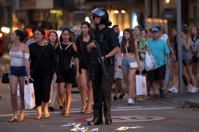 Un policía evacúa a unos transeúntes luego de que una furgoneta atropellara a unas personas en la avenida Las Ramblas en Barcelona, España, ago 17, 2017. REUTERS/Stringer  ATENCIÓN EDITORES: LAS LEYES ESPAÑOLAS REQUIEREN QUE LOS ROSTROS DE MENORES DE EDAD SEAN CUBIERTOS EN PUBLICACIONES DISTRIBUIDAS DENTRO DE SU TERRITORIO.  PROHIBIDA SU REVENTA Y SU ALMACENAMIENTO