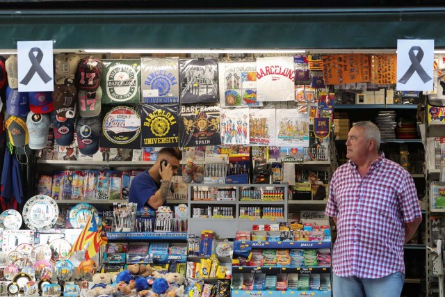 Placards with black ribbons hang on a kiosk in the area where a van crashed into pedestrians at Las Ramblas street in Barcelona, Spain August 18, 2017. REUTERS/Sergio Perez