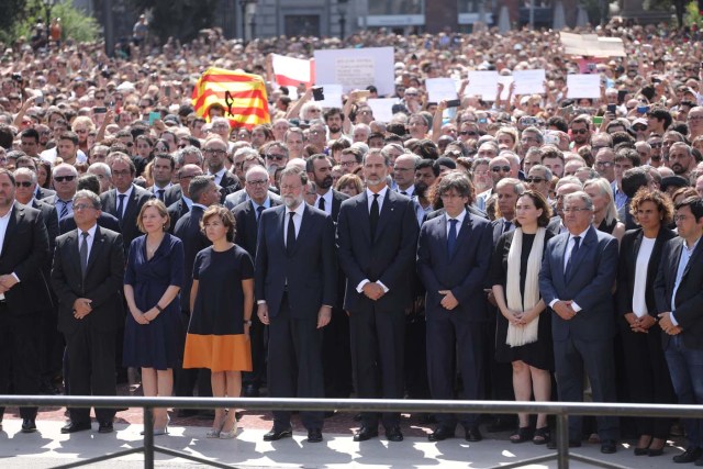 King Felipe of Spain sits between Prime Minister Mariano Rajoy and President of the Generalitat of Catalonia Carles Puigdemont as they observe a minute of silence in Placa de Catalunya, a day after a van crashed into pedestrians at Las Ramblas in Barcelona, Spain August 18, 2017. REUTERS/Sergio Perez