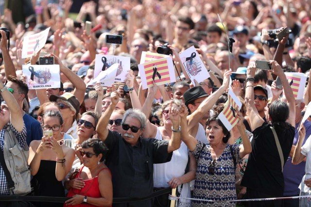 People hold banners as they observe a minute of silence in Placa de Catalunya, a day after a van crashed into pedestrians at Las Ramblas in Barcelona, Spain August 18, 2017. REUTERS/Sergio Perez