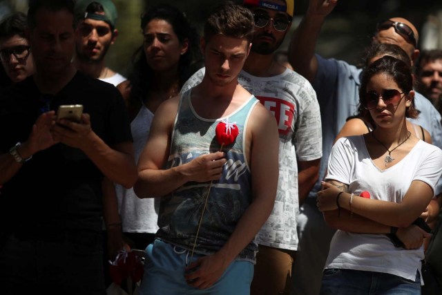 People react at an impromptu memorial a day after a van crashed into pedestrians at Las Ramblas in Barcelona, Spain August 18, 2017. REUTERS/Susana Vera