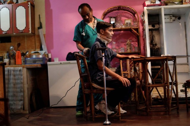 Jofre Rodriguez, 18, who was injured during a protest against Venezuela's President Nicolas Maduro's government, poses for a photograph at his home in Turmero, Venezuela, August 11, 2017. Rodriguez said his jaw was fractured by a gunshot on June 26, 2017. He underwent surgery to remove a projectile that was lodged in a vertebra but he still needs treatment and jaw reconstruction surgery. "This constituent assembly is a perversion meant to consolidate them (the ruling party) in power. I'm protesting against that. It saddens me to see my country like this. With Chavez, we had a dictatorship with a 'political leader,' with Maduro we have a political disaster," he said. "I'm only 18 years old, but I'm living through the decline of Venezuela. Was it worth it? Yes, like those who died, what happened to me was a sacrifice that has inspired many people in the struggle." REUTERS/Ueslei Marcelino SEARCH "VENEZUELA INJURIES" FOR THIS STORY. SEARCH "WIDER IMAGE" FOR ALL STORIES.