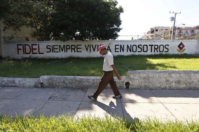 HAB104. LA HABANA (CUBA), 13/08/2017.- Un hombre pasa junto a un cartel pintado en un muro, referente al líder de la revolución cubana Fidel Castro, en el día de su 91 cumpleaños, hoy, domingo 13 de agosto del 2017, en La Habana (Cuba). Cuba recuerda hoy el 91 aniversario del natalicio del líder de la revolución, Fidel Castro, el primero tras su fallecimiento hace nueve meses, que se celebra este domingo con múltiples actos y una amplia cobertura en los medios estatales de la isla que resaltan el legado del "invicto y eterno Comandante". EFE/Ernesto Mastrascusa