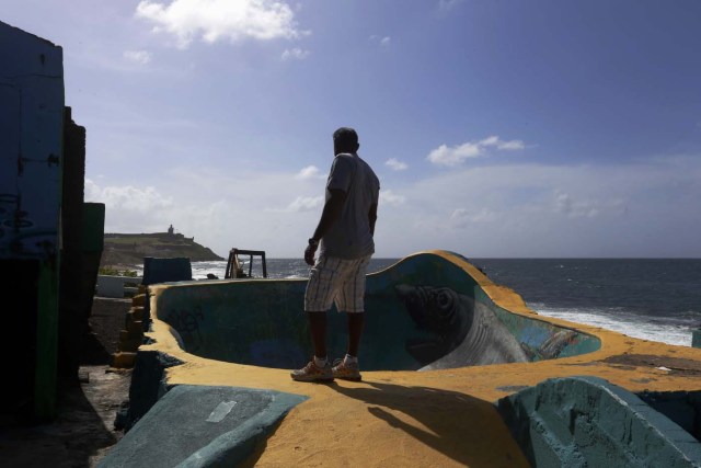 ACOMPAÑA CRÓNICA: P.RICO TURISMO SJ009. SAN JUAN (PUERTO RICO), 26/08/2017.- Fotografía fechada el 18 de agosto de 2017 que muestra al pescador Roberto Viruet junto al "bowl" del barrio de La Perla, en San Juan (Puerto Rico). La Perla, uno de los barrios más conocidos de la capital, ha resurgido este año con esplendor tras el remozamiento de 400 casas situadas en el histórico casco del Viejo San Juan y la visita de cientos de curiosos y turistas por el rodaje del vídeo del exitoso tema "Despacito". EFE/Thais Llorca