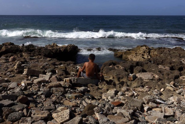 ACOMPAÑA CRÓNICA: P.RICO TURISMO SJ006. SAN JUAN (PUERTO RICO), 26/08/2017.- Fotografía fechada el 18 de agosto de 2017 que muestra a un niño jugando junto al mar en el barrio de La Perla de San Juan (Puerto Rico). La Perla, uno de los barrios más conocidos de la capital, ha resurgido este año con esplendor tras el remozamiento de 400 casas situadas en el histórico casco del Viejo San Juan y la visita de cientos de curiosos y turistas por el rodaje del vídeo del exitoso tema "Despacito". EFE/Thais Llorca