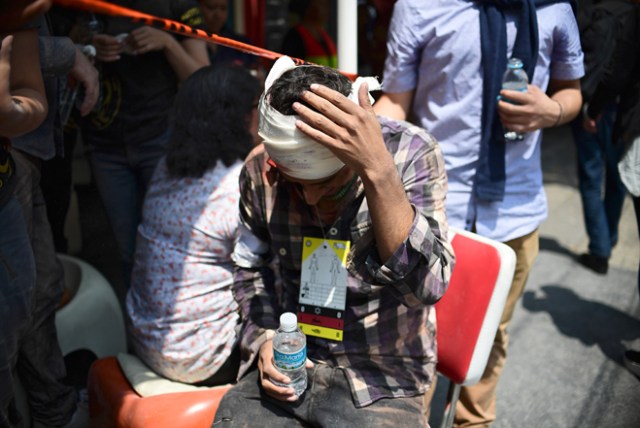 A man gestures after being injured on the head during a quake in Mexico City on September 19, 2017. A powerful earthquake shook Mexico City on Tuesday, causing panic among the megalopolis' 20 million inhabitants on the 32nd anniversary of a devastating 1985 quake. The US Geological Survey put the quake's magnitude at 7.1 while Mexico's Seismological Institute said it measured 6.8 on its scale. The institute said the quake's epicenter was seven kilometers west of Chiautla de Tapia, in the neighboring state of Puebla. / AFP PHOTO / Ronaldo SCHEMIDT