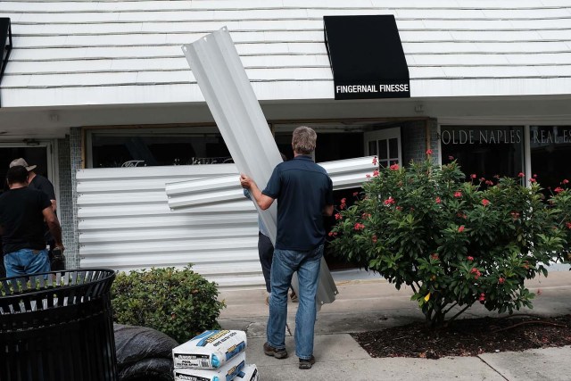 NAPLES, FL - SEPTEMBER 09: Metal siding is placed in front of a business in downtown Naples before the arrival of Hurricane Irma into Southwest Florida on September 9, 2017 in Naples, Florida. The Naples area could begin to feel hurricane-force winds from Irma by 11 a.m. Sunday and experience wind gusts over 100 mph from Sunday through Monday.   Spencer Platt/Getty Images/AFP