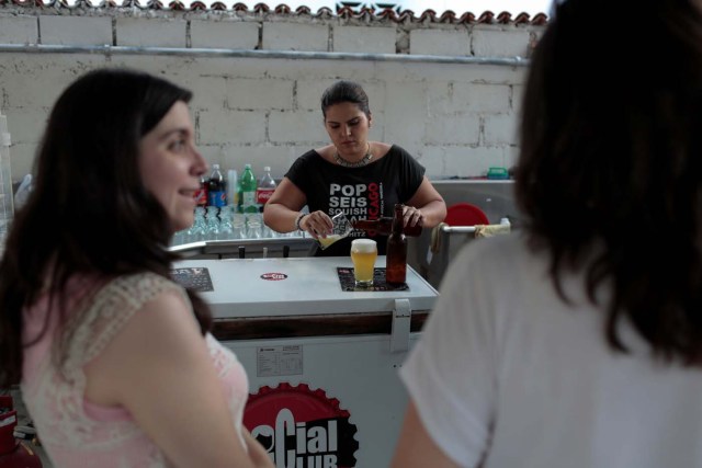 A worker serves craft beer in a beer garden at the garage of Social Club brewery in Caracas, Venezuela, September 15, 2017. Picture taken September 15, 2017. REUTERS/Marco Bello