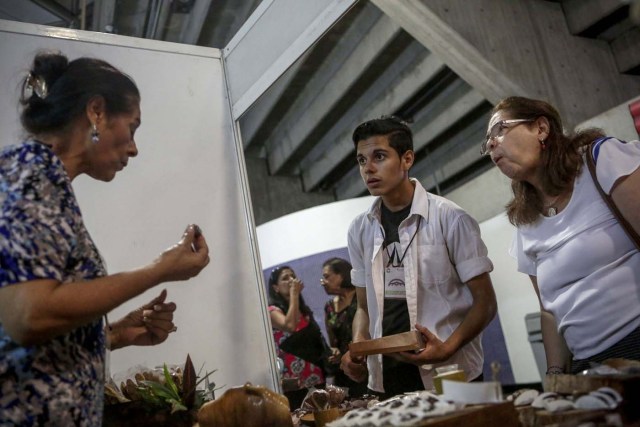 ACOMPAÑA CRÓNICA: VENEZUELA GASTRONOMÍA. CAR05. CARACAS (VENEZUELA), 29/09/2017.- Fotografía fechada el 28 de septiembre de 2017 que muestra a varias personas mientras comen bombones de chocolate en una exhibición de productos derivados del cacao en Caracas (Venezuela). La industria del chocolate en Venezuela organiza su V Expoferia Internacional para "darle impulso" exportador a sus productos, en medio de la rampante crisis económica que atraviesa el país petrolero, y con la mira puesta en otro récord Guinness que promocione el llamado "mejor cacao del mundo". EFE/Cristian Hernández