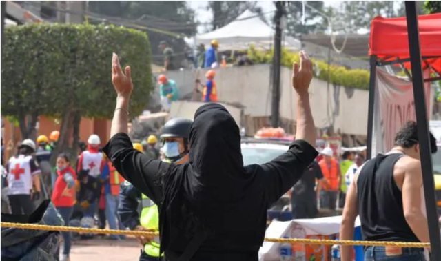 La súplica de una mujer durante la búsqueda de sobrevivientes en el derrumbe del colegio en la Ciudad de México (AFP PHOTO / Omar TORRES)