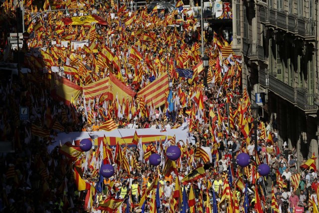 Protesters hold Spanish flags during a demonstration called by "Societat Civil Catalana" (Catalan Civil Society) to support the unity of Spain on October 8, 2017 in Barcelona. Spain braced for more protests despite tentative signs that the sides may be seeking to defuse the crisis after Madrid offered a first apology to Catalans injured by police during their outlawed independence vote. / AFP PHOTO / PAU BARRENA