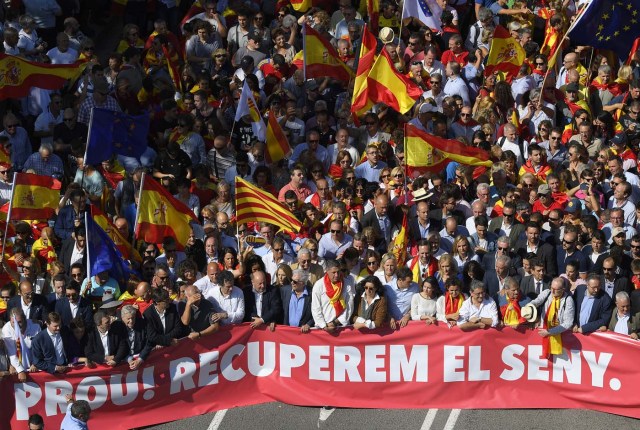 Leader of the Popular Party of Catalonia (PPC) Xavier Garcia Albiol and Peruvian writer Mario Vargas Llosa (first row,center) walk behind a banner reading in Catalan "Enough, regain lucidity" during a demonstration called by "Societat Civil Catalans" (Catalan Civil Society) to support the unity of Spain on October 8, 2017 in Barcelona. Spain braced for more protests despite tentative signs that the sides may be seeking to defuse the crisis after Madrid offered a first apology to Catalans injured by police during their outlawed independence vote. / AFP PHOTO / LLUIS GENE