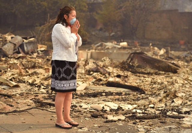 Los propietarios de viviendas Martha Márquez miran por encima de su hogar quemado en Santa Rosa, California el 10 de octubre de 2017. Los bomberos alentados por el debilitamiento de los vientos estaban luchando contra 17 grandes incendios forestales el martes en California que han dejado al menos 13 personas muertas, país.