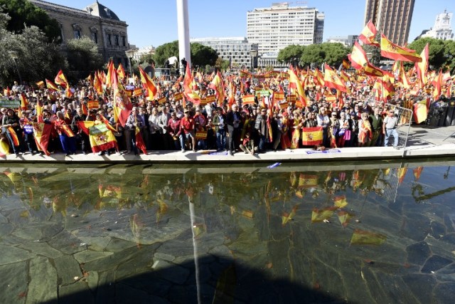 La gente agita banderas españolas durante una manifestación llamando a la unidad en la Plaza de Colón en Madrid el 28 de octubre de 2017, un día después de que se impuso el control directo sobre Cataluña en un intento por separarse de España. España se movió para afirmar el dominio directo sobre Cataluña, reemplazando a sus funcionarios ejecutivos y altos para sofocar un impulso de independencia que ha sumido al país en una crisis y ha puesto nerviosa a la Europa secesionista. / AFP PHOTO / JAVIER SORIANO