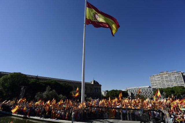 Una bandera gigante de España revolotea sobre las personas ondeando banderas españolas durante una manifestación llamando a la unidad en la Plaza de Colón en Madrid el 28 de octubre de 2017, un día después de que se impuso el control directo sobre Cataluña en un intento por separarse de España. España se movió para afirmar el dominio directo sobre Cataluña, reemplazando a sus funcionarios ejecutivos y altos para sofocar un impulso de independencia que ha sumido al país en una crisis y ha puesto nerviosa a la Europa secesionista. / AFP PHOTO / JAVIER SORIANO