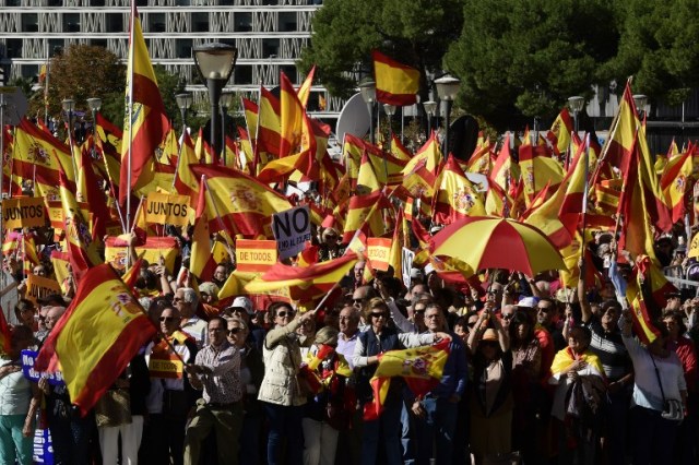 La gente agita banderas españolas durante una manifestación llamando a la unidad en la Plaza de Colón en Madrid el 28 de octubre de 2017, un día después de que se impuso el control directo sobre Cataluña en un intento por separarse de España. España se movió para afirmar el dominio directo sobre Cataluña, reemplazando a sus funcionarios ejecutivos y altos para sofocar un impulso de independencia que ha sumido al país en una crisis y ha puesto nerviosa a la Europa secesionista. / AFP PHOTO / JAVIER SORIANO