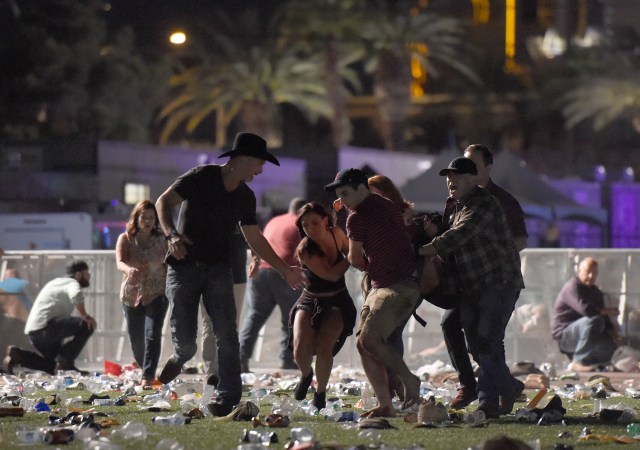 LAS VEGAS, NV - 01 DE OCTUBRE: (NOTA DE LOS EDITORES: La imagen contiene contenido gráfico.) La gente lleva un peson en el festival de música country de la cosecha de la ruta 91 después de que el fuego aparente del arma fuera oído el 1 de octubre de 2017 en Las Vegas, Nevada. Hay informes de un tirador activo alrededor del Mandalay Bay Resort y Casino. David Becker / Getty Images / AFP