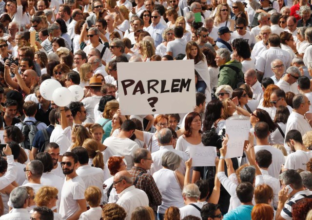 A woman holds up a sign that redads "shall we talk?" in Catalan during a demonstration in a square in Barcelona, Spain, October 7, 2017 REUTERS/Eric Gaillard