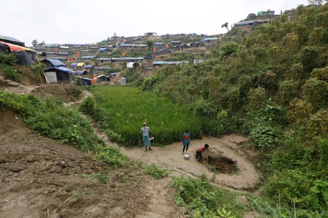 Las niñas refugiadas Rohingya recogen agua de un pozo poco profundo, excavado en la arena del campamento de refugiados de Uchiprang, cerca de Cox's Bazar, Bangladesh 29 de octubre de 2017. REUTERS / Adnan Abidi