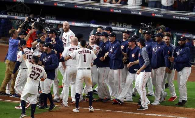 El tercera base de los Houston Astros Alex Bregman (2) celebra con sus compañeros de equipo después de conducir en la carrera ganadora con un sencillo productor ante los Dodgers de Los Angeles en la décima entrada en el quinto juego de la Serie Mundial 2017 en el Minute Maid Park. Crédito obligatorio: Matthew Emmons-USA TODAY Sports