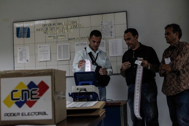 Miembros de mesa y testigos participan en el cierre de mesas y auditoría de actas, en un centro electoral tras las elecciones regionales hoy, domingo 15 de octubre de 2017, en Caracas (Venezuela). Los venezolanos votaron hoy a un ritmo lento y sin grandes colas en muchos de los colegios durante la primera mitad de una jornada electoral de los comicios para elegir los gobernadores de 23 estados marcada por los retrasos en la apertura de las mesas. EFE/Cristian Hernández