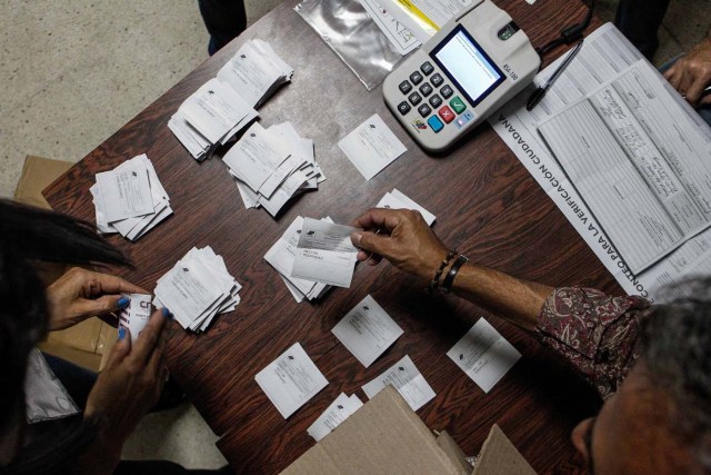 VEZ21. CARACAS (VENEZUELA), 15/10/2017.- Miembros de mesa y testigos participan en el cierre de mesas y auditoría de actas, en un centro electoral tras las elecciones regionales hoy, domingo 15 de octubre de 2017, en Caracas (Venezuela). Los venezolanos votaron hoy a un ritmo lento y sin grandes colas en muchos de los colegios durante la primera mitad de una jornada electoral de los comicios para elegir los gobernadores de 23 estados marcada por los retrasos en la apertura de las mesas. La oposición venezolana, reunida en la Mesa de la Unidad Democrática (MUD), pidió hoy que se cierren los centros donde ya no haya electores para iniciar conteo y exigió que se mantengan abiertos aquellos donde aún haya gente en fila para votar, pues resaltó que esto está establecido en la ley. EFE/Cristian Hernández