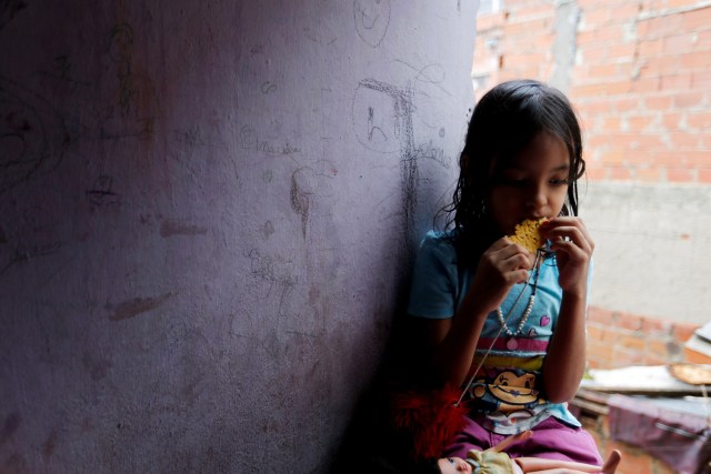 Una de las hijas de Yennifer Padrón y Víctor Córdova come una arepa en la habitación familiar de la casa que comparten en la favela de Petare en Caracas, Venezuela, el 21 de agosto de 2017. Foto tomada el 21 de agosto de 2017. Para coincidir con la Característica VENEZUELA-CHILDREN / REUTERS / Andres Martinez Casares