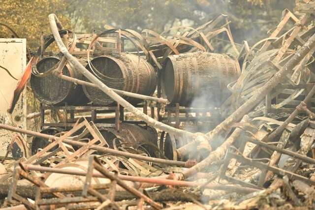 Burned wine barrels are seen at a destroyed Paradise Ridge Winery in Santa Rosa, California on October 10, 2017. Firefighters encouraged by weakening winds were battling 17 large wildfires on Tuesday in California which have left at least 13 people dead, thousands homeless and ravaged the state's famed wine country. / AFP PHOTO / JOSH EDELSON