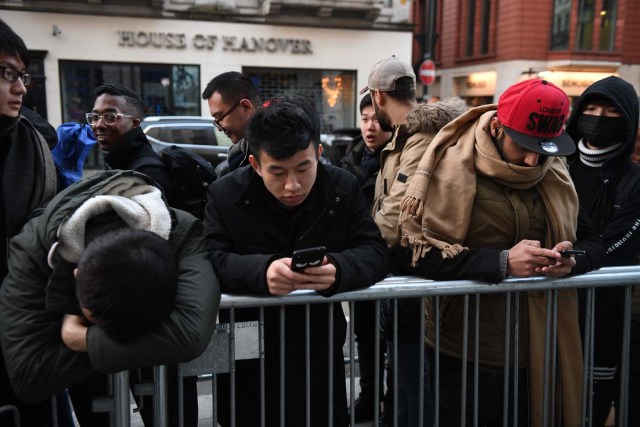 People queue outside Apple's Regent Street store in central London on November 3, 2017 waiting for the store to open on the say of the launch of the Apple iPhone X. Apple's flagship iPhone X hit stores on November 3, as the world's most valuable company predicted bumper sales despite the handset's eye-watering price tag and celebrated a surge in profits. The device features facial recognition, cordless charging and an edge-to-edge screen made of organic light-emitting diodes used in high-end televisions. It marks the 10th anniversary of the first iPhone release and is released in about 50 markets around the world. / AFP PHOTO / Chris J Ratcliffe